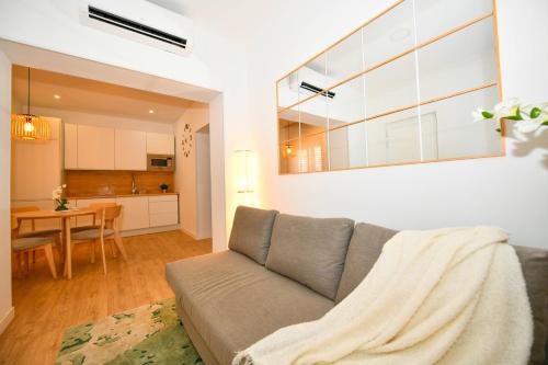 a living room with a couch and a kitchen at Sandy Shores Oasis in Playa de San Juan
