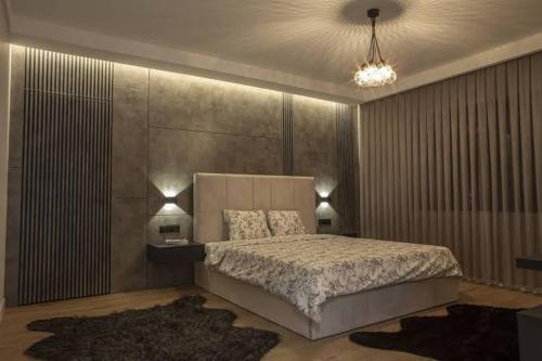 a bedroom with a large bed and two lamps at Aurora suit in Podgorica