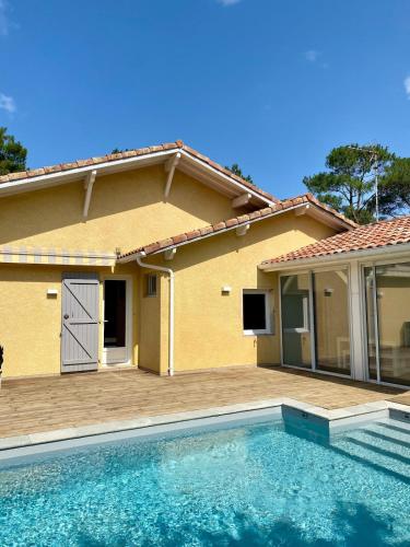 a house with a swimming pool in front of a house at Villa Labenne Ocean - piscine, 500 mètres de la plage in Labenne