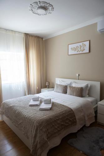 a bedroom with a large bed with two towels on it at Residencial Princesa do Ave in Vila do Conde