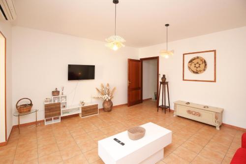 a living room with a couch and a tv on the wall at Roma 19 in Castelsardo