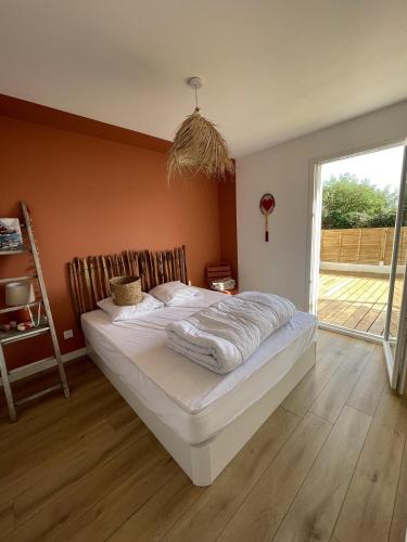 une chambre avec un grand lit dans une pièce dans l'établissement Casa Côme, à Saint-Vincent-sur-Jard