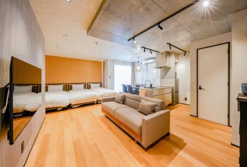 a bedroom with a bed and a couch in a room at NESTo KAMATA in Tokyo