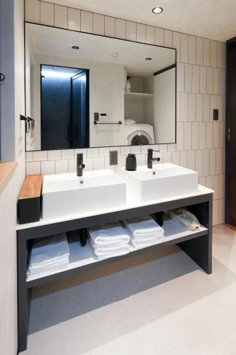 a bathroom with two sinks and a large mirror at NESTo KAMATA in Tokyo