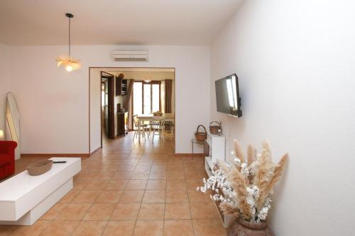 a living room with a couch and a tv on a wall at Roma 19 in Castelsardo
