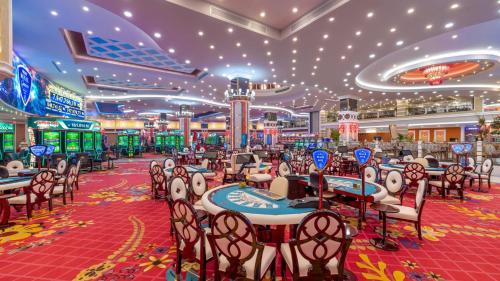 a casino on a cruise ship with tables and chairs at Merit Royal Gardens Hotel & Casino in İskele