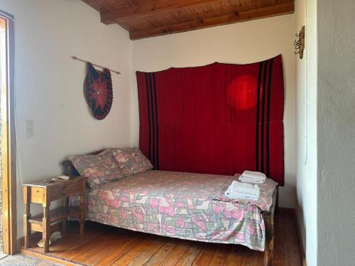 a small bed in a room with a red curtain at Koumos in Kalyves