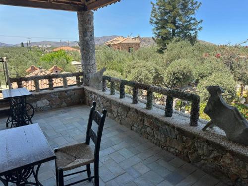 a patio with a dog statue on a stone wall at Koumos in Kalyves