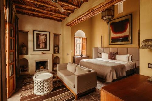a bedroom with a bed and a chair and a fireplace at Ryad Dyor in Marrakech