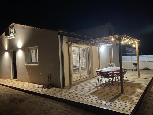 - une table et des chaises sur une terrasse la nuit dans l'établissement Casa Côme, à Saint-Vincent-sur-Jard
