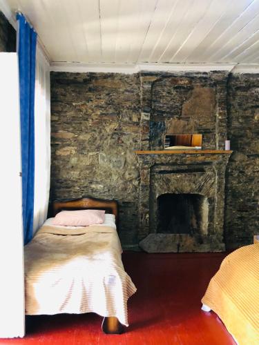 a bedroom with a bed with a stone fireplace at Ela in Ushguli