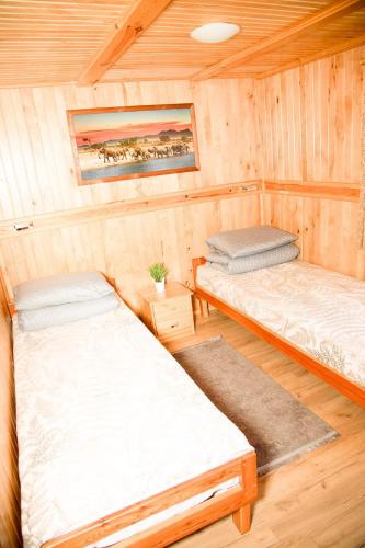 a room with two beds in a cabin at Domki Letniskowe Bursztynek in Grzybowo