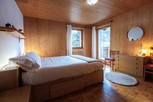 a bedroom with a bed in a room with wooden walls at Chalet Beppe in Bormio