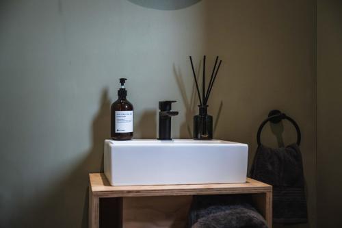 a white sink with two bottles on a wooden table at Castor in Abergele