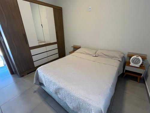 a small bedroom with a bed and a mirror at Casa Jardim Primavera in Cunha