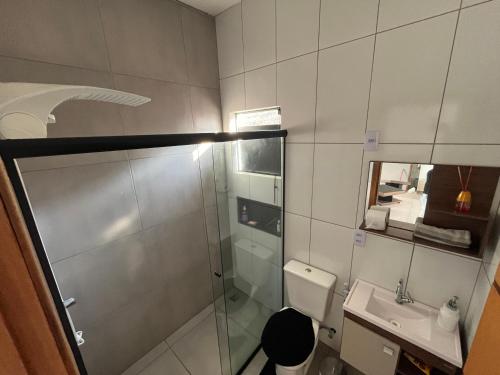 a bathroom with a shower and a toilet and a sink at Casa Jardim Primavera in Cunha