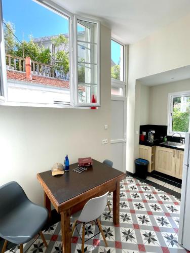 une cuisine avec une table et des chaises dans une pièce dans l'établissement Arcachon, quartier historique, Maison de ville à 2 pas de la plage, à Arcachon