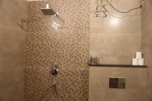 a bathroom with a shower with a tiled wall at Vedic Dham Ganga in Rishīkesh