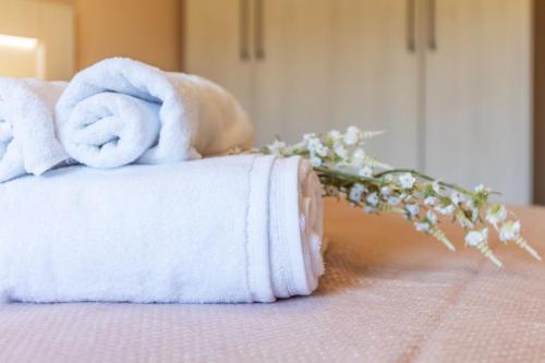 a pile of towels and flowers on a bed at Apartamento Larrazu II Agroturismo Baztán in Arráyoz