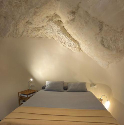 a bedroom with a bed with a stone ceiling at Bellísima cueva acogedora "Casa Olivia" in Gor