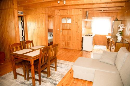 a kitchen and dining room with a table and chairs at Domki Letniskowe Bursztynek in Grzybowo