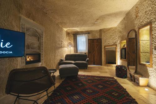 a living room with a couch and chairs and a tv at Vie Cappadocia - Adults Only in Nevsehir