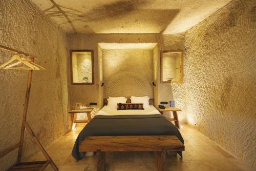 a bedroom with a bed in a stone room at Vie Cappadocia - Adults Only in Nevsehir