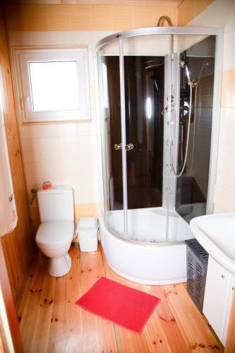 a bathroom with a tub and a toilet and a sink at Domki Letniskowe Bursztynek in Grzybowo
