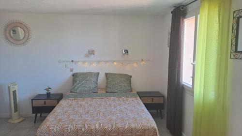 ein Schlafzimmer mit einem Bett mit zwei Tischen und einem Fenster in der Unterkunft Ground floor of villa in Brando