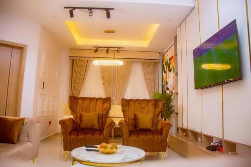 a living room with two chairs and a table at Zee in Okunaja