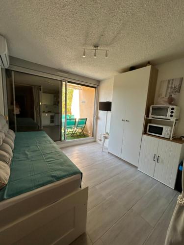 Il comprend une chambre avec un lit et une cuisine équipée d'un four micro-ondes. dans l'établissement La Calypso, à Cavalaire-sur-Mer