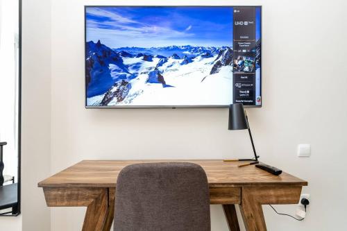 a tv screen hanging on a wall with a desk at Special Rates - Elegant Studio - Golf Views in Dubai