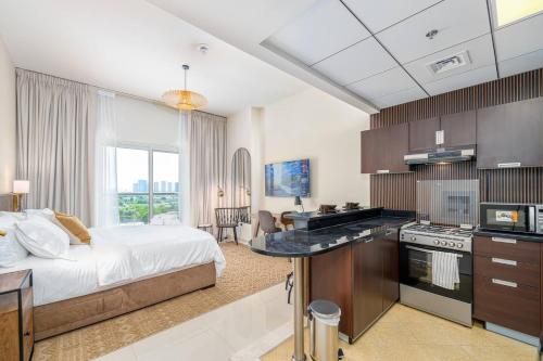 a bedroom with a bed and a kitchen with a stove at Special Rates - Elegant Studio - Golf Views in Dubai