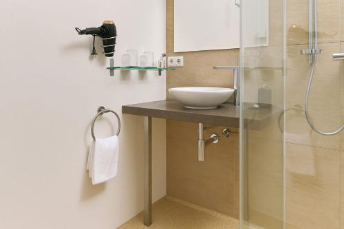 a bathroom with a sink and a shower at WURZENBERG Hotel Lodges Südsteiermark in Gamlitz
