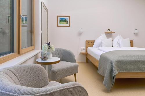 a hotel room with a bed and a chair at WURZENBERG Hotel Lodges Südsteiermark in Gamlitz