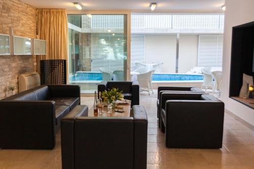 a living room with black leather couches and a table at Illustrious Brac Villa 6 Bedrooms Villa Bol Waterfront Private Pool & Balcony With Beautiful Views Bol in Bol