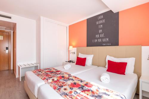 a bedroom with a large white bed with red pillows at THE Hotel MASA Almirante LISBON Stylish in Lisbon