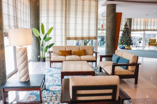 a living room with a couch and a christmas tree at Hotel Santa Cruz in Santa Cruz