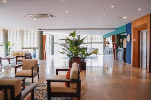 a lobby with chairs and tables in a building at Hotel Santa Cruz in Santa Cruz