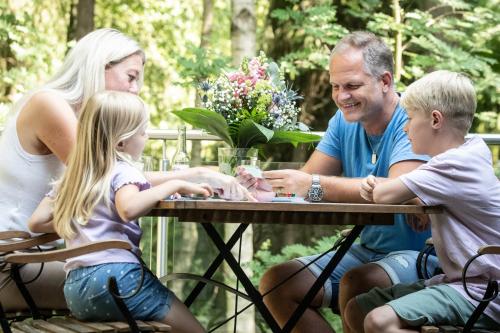 a family sitting at a table playing a game at Tierpark Entdeckerhäuser in Wagenfeld