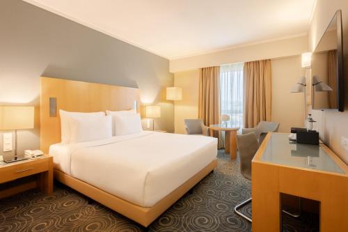 a hotel room with a bed and a desk at SANA Malhoa Hotel in Lisbon