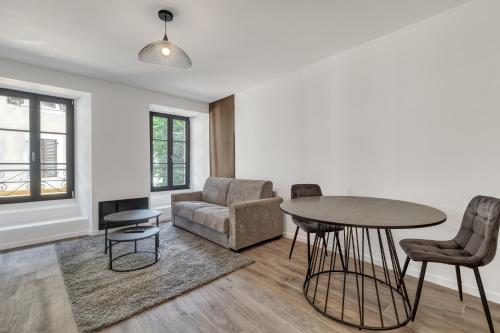 a living room with a table and chairs at Studio de charme rénové calme et lumineux in Thonon-les-Bains