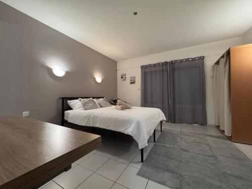 a bedroom with a bed and a table at AppartHotel le Nid Marin in Aytré