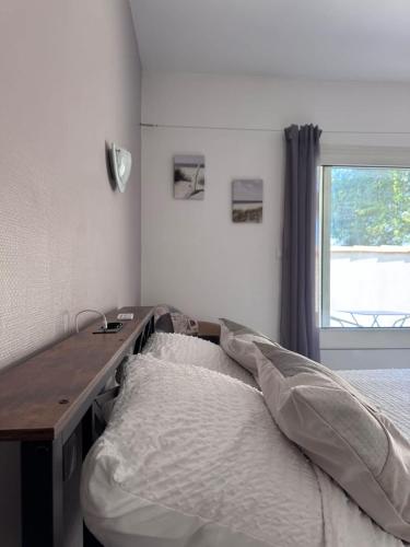 a bedroom with a bed and a desk and a window at AppartHotel le Nid Marin in Aytré