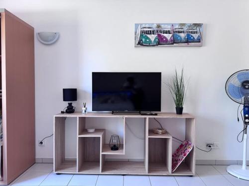 a living room with a desk with a television at AppartHotel le Nid Marin in Aytré