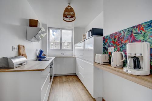 Una cocina con gabinetes blancos y encimera. en La Traversée Brestoise - Appartement tout confort avec parking privatif au centre-ville, en Brest