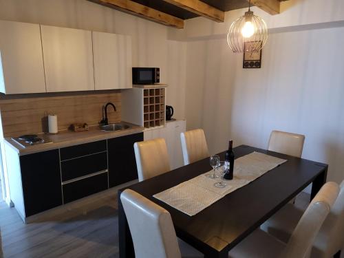 a dining room table with chairs and a kitchen at Stan na dan BOVKA in Široki Brijeg