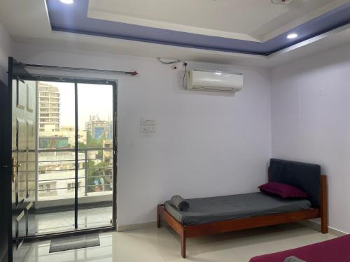 a room with a bench in a room with a window at Elysium Inn in Hyderabad