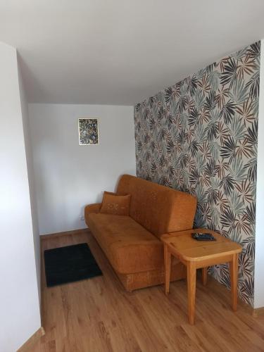 a living room with a couch and a table at Domki Letniskowe Bursztynek in Grzybowo