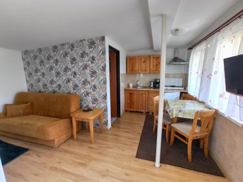 a living room with a couch and a table at Domki Letniskowe Bursztynek in Grzybowo